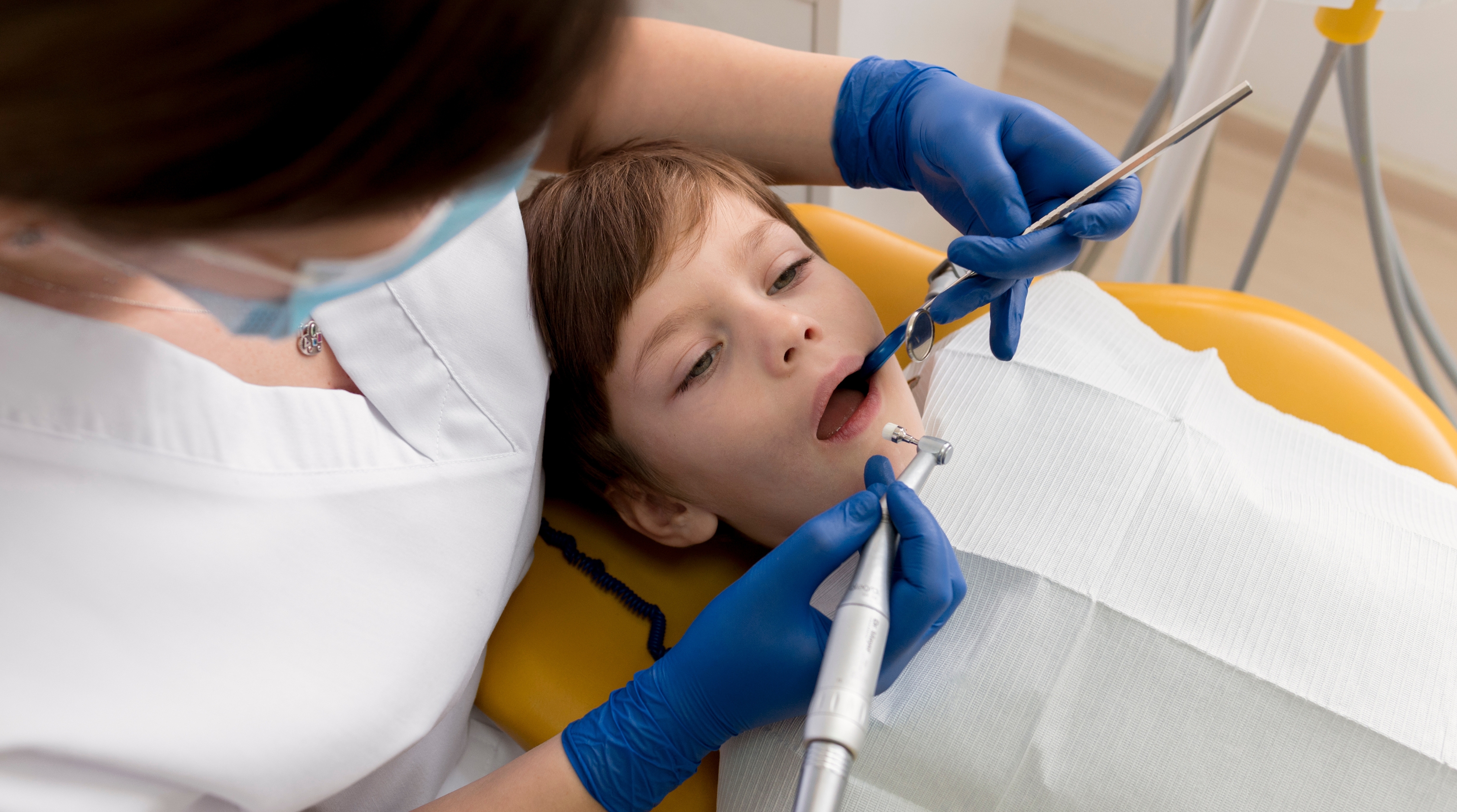 Pediatric dentist performing cavity filling for a child in Coimbatore